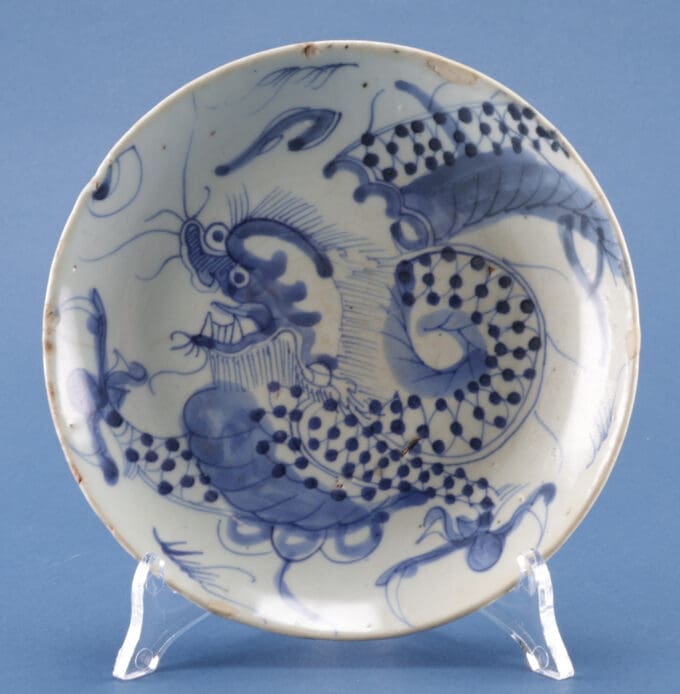 Porseleinen bord met blauwe draakmotief.