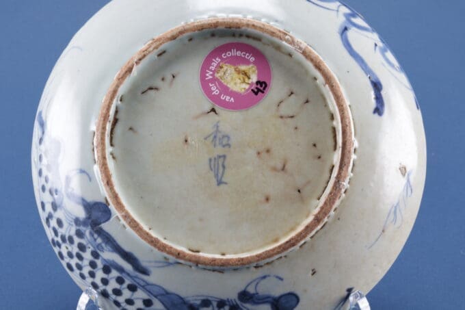 Onderkant van keramische schaal met stempel en sticker.